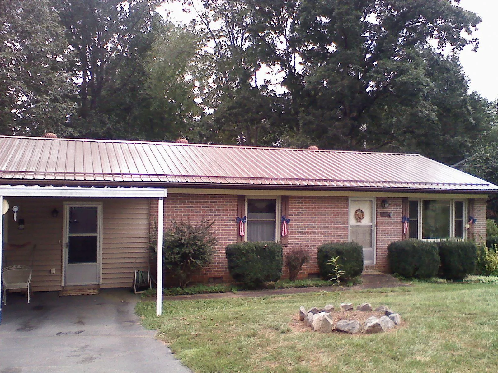 Bronze metal roof and carport on a brick ranch home — Roof Repair work by our crew in Wellington